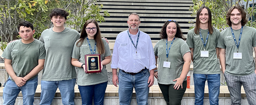 Students with Dr. Andel holding plaque.