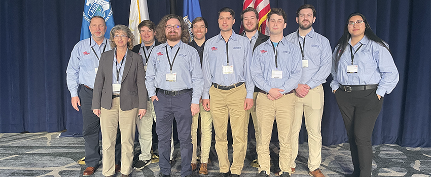 Students with professors in front of flags.