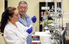 Student working in chemistry lab with professor