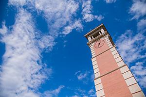 Moulton Tower clock with clouds behind it.